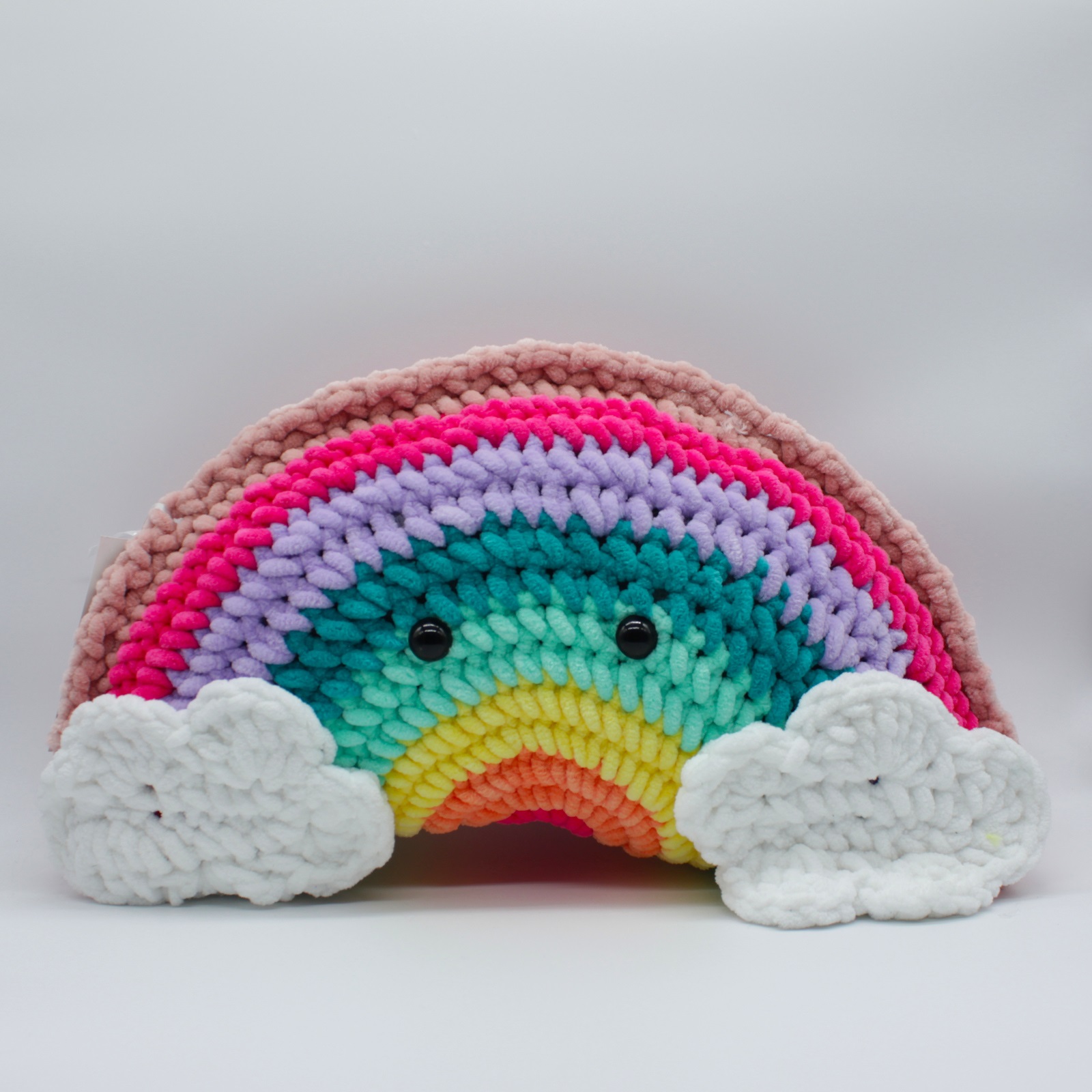 a rainbow pillow with clouds